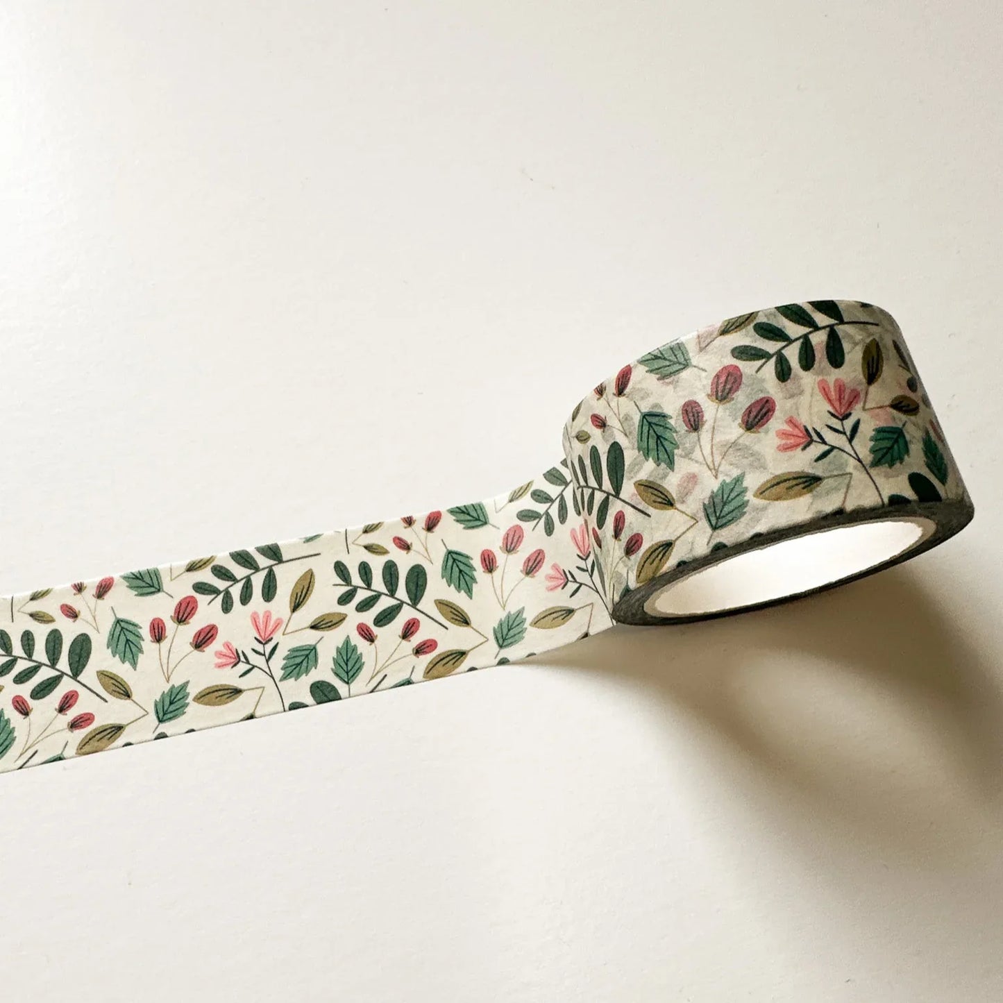 Close-up of Overgrown washi tape showing delicate red, yellow, blue, and green botanical details on cream tape.