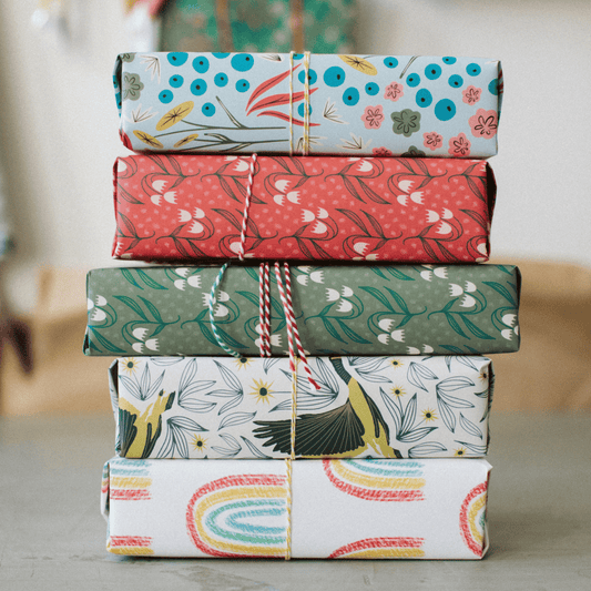 Stack of Rebecca Jane Woolbright wrapping paper on a table. 