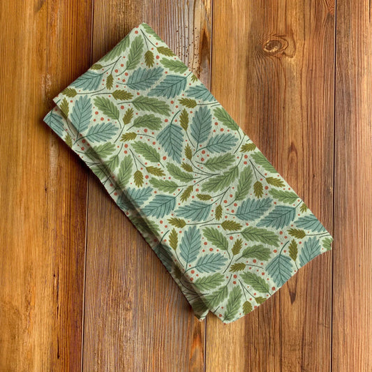 green and blue leaf patterned tea towel on wood floor
