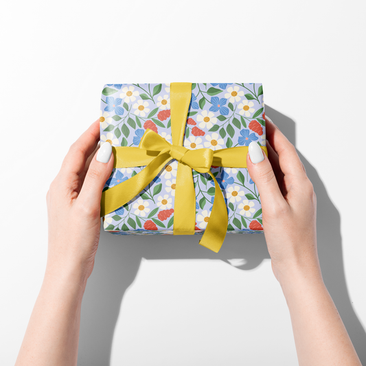 two hands holding a wrapped gift with yellow ribbon