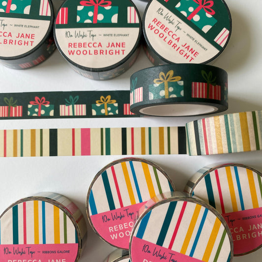 two different washi tape rolls side by side, one striped the other with wrapped presents showing the design on a desk