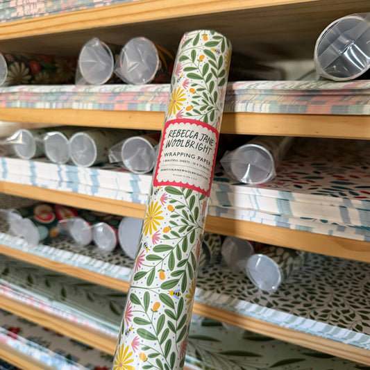 Wrapping paper roll in front of shelves filled with more rolls and sheets