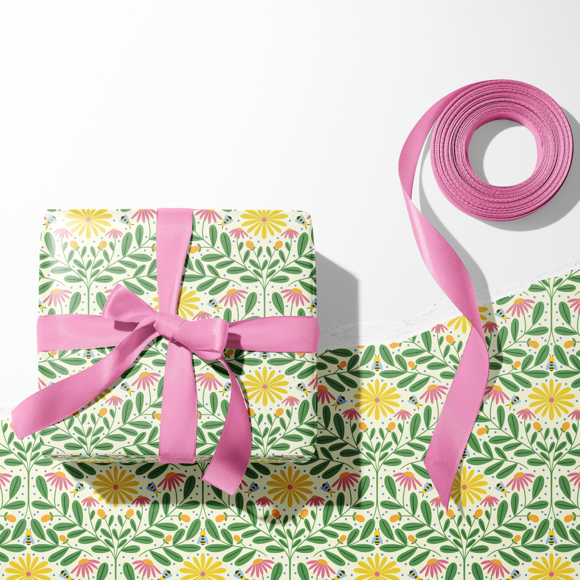 Bee Kind wrapping paper with bees and colorful flowers on gift box with pink ribbon, floral gift wrap