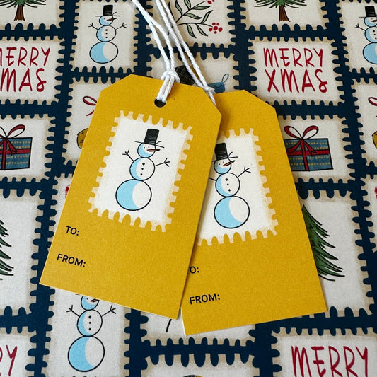 Cute snowmen on a gift tag set against postage stamp wrapping paper