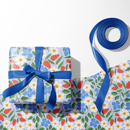 Garden Path floral gift wrap on present with blue ribbon and ribbon roll, daisy wrapping paper sheets
