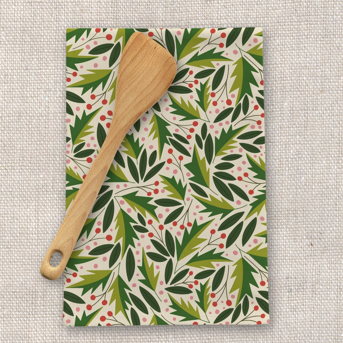 Patterned kitchen towel with wooden spoon on a textured surface