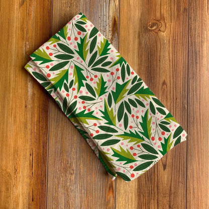 Folded fabric with green leaf pattern on a wooden surface