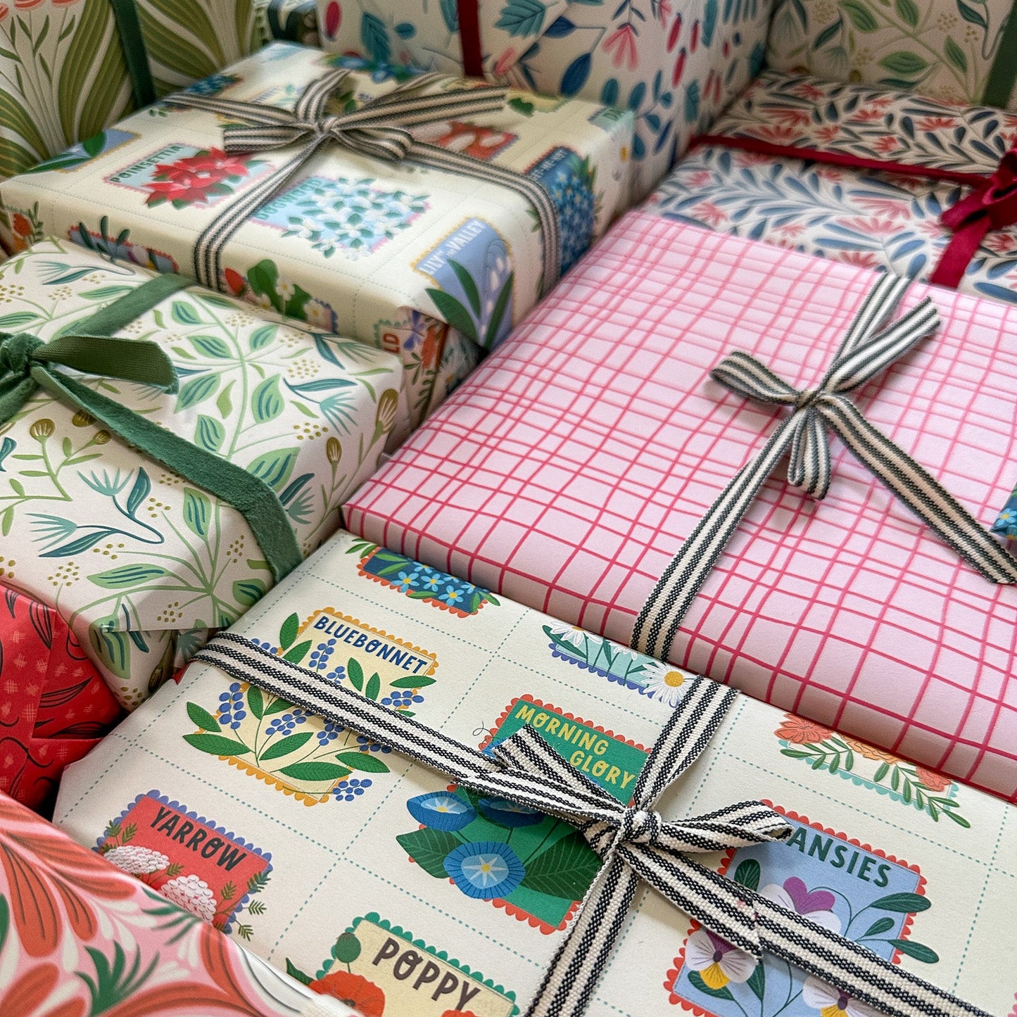 Assorted wrapped gifts with colorful patterns and ribbons drawn by Rebecca Woolbright