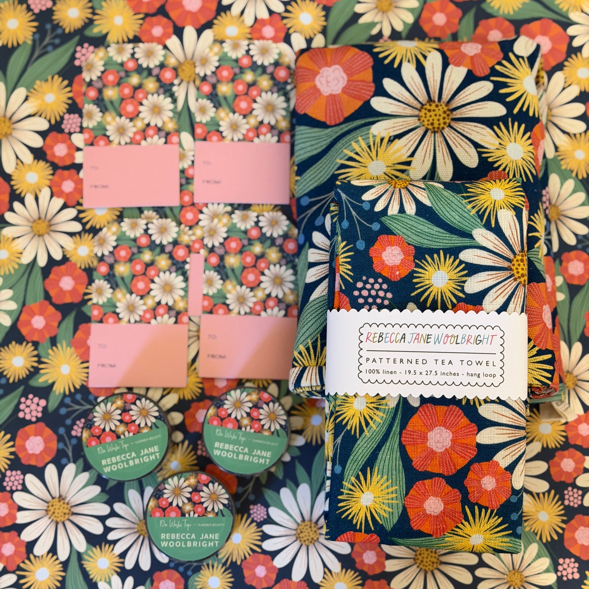 Floral patterned tea towel with brand label on a matching wrapping paper background