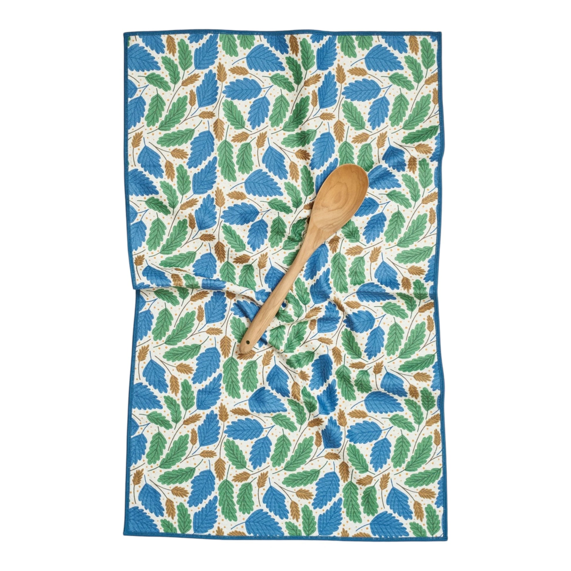 Towel with leaf pattern and wooden spoon on a white background