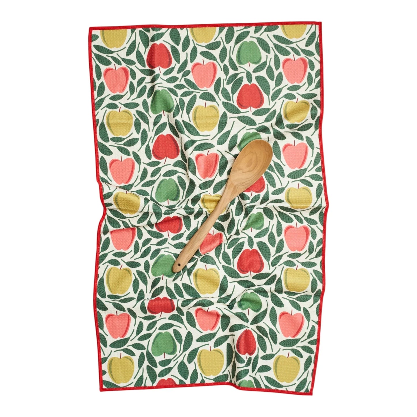 Kitchen towel with apple pattern and wooden spoon on a white background