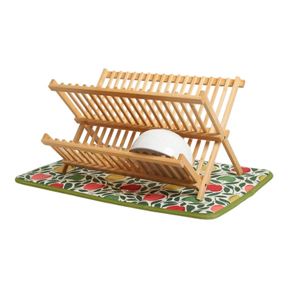 Wooden dish rack with a white bowl on a green mat with red and yellow patterns
