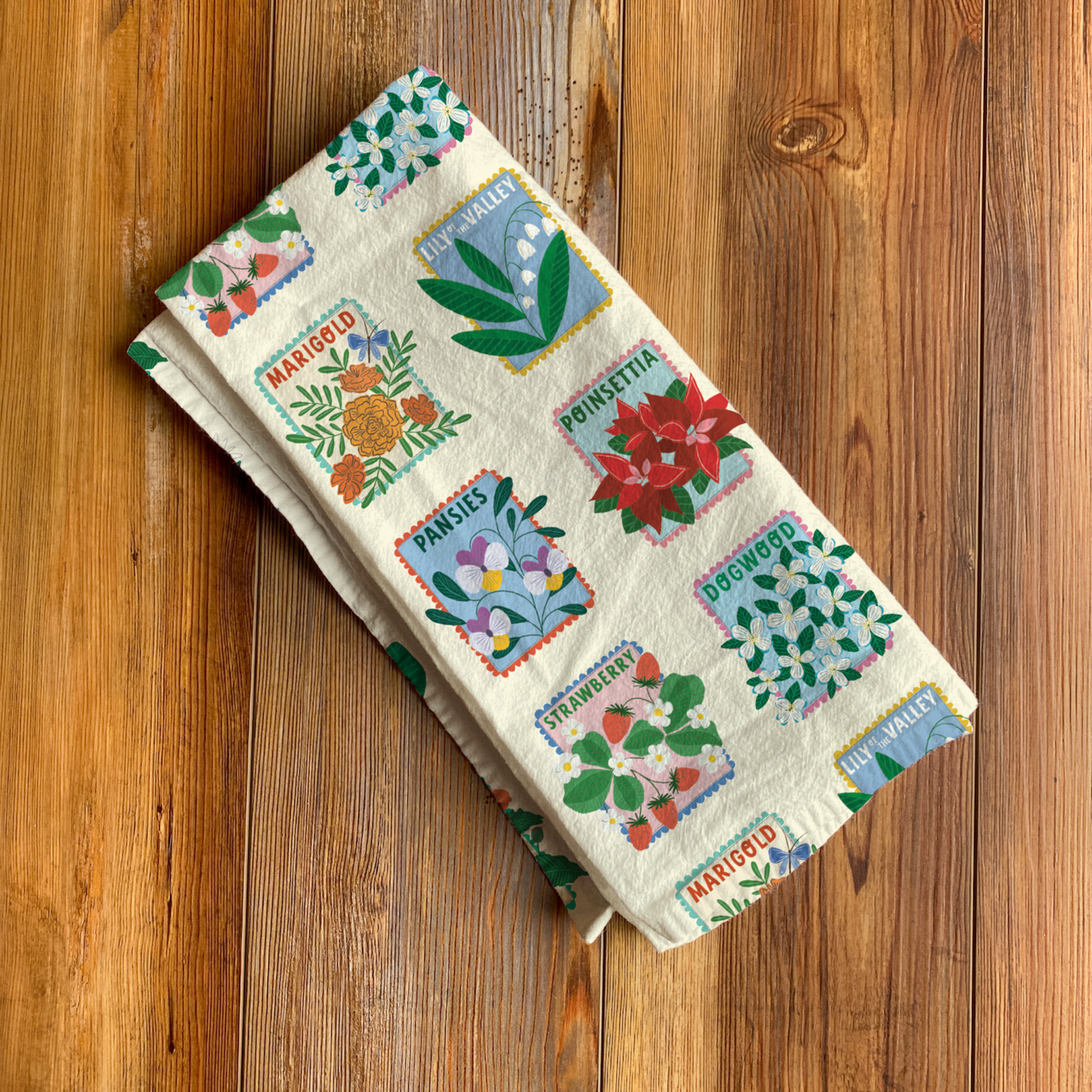 Garden Bed Tea Towel - Folded Garden Bed tea towel by Rebecca Jane Woolbright with colorful patterned botanical design